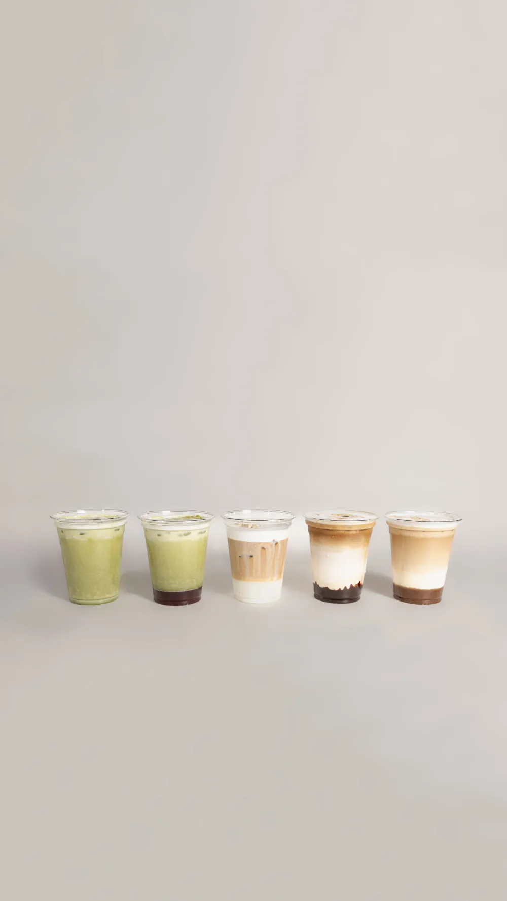 Cinco vasos de iced latte alineados — matcha, dalgona, espresso y café con leche
